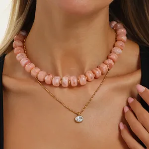 Halskette aus rosa marmorierten Harzperlen mit vergoldetem Zirkonia-Anhänger aus Edelstahl.