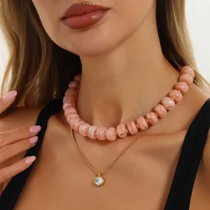 Detail von rosa marmorierter Harzperlen-Choker und Goldkette mit Zirkonia-Anhänger