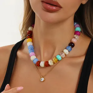 Nahaufnahme einer bunten Harzperlenkette mit goldenem Zirkonia-Anhänger Detail