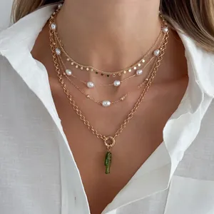 Gros plan d'un collier doré à plusieurs rangs avec perles et pendentif poisson