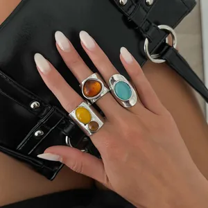 Vintage silver wide band rings featuring colorful resin inlay on a manicured hand.