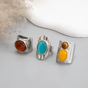 Macro detail view of retro silver-tone wide rings with colorful resin gemstone inlays.
