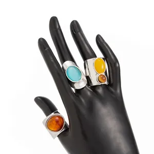 Vintage wide metallic open rings with colorful oval resin stones on display hand