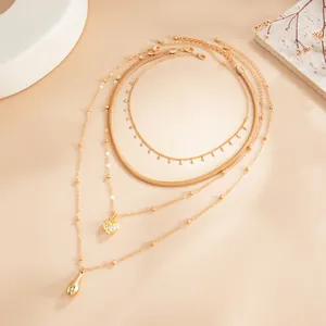 Vue détaillée du collier doré multicouche avec pendentifs en cœur et goutte d'eau