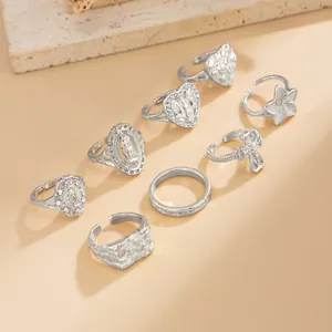 Detailed display of silver hip-hop ring set featuring hollow heart and cross motifs