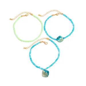 Detailed macro shot of bohemian colorful bead anklets featuring natural shell pendants