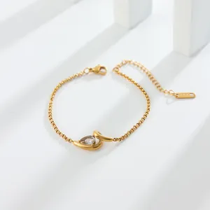 Vue détaillée d'un bracelet en acier doré orné d'un pendentif en zircone en forme de larme.
