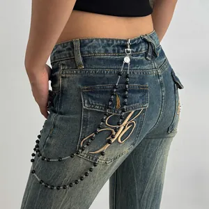 Detail view showing a hip-hop style trouser chain with black beads on blue denim jeans