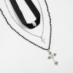 Close-up of gothic layered necklace set featuring a skull and ornate cross pendants