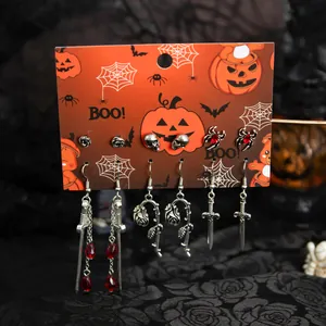 Detailansicht des Halloween-Ohrring-Sets mit Totenköpfen, Rosen und roten Tropfen.