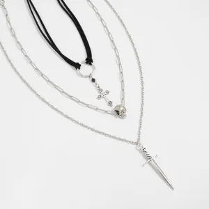 Detailed view of gothic layered necklace set with silver cross, skull, and sword pendants