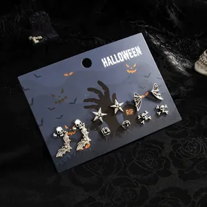 Detailansicht eines silbernen Halloween-Ohrring-Sets mit Fledermaus- und Totenkopfmotiven
