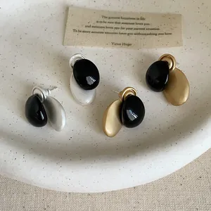 Vista detallada del acabado único en contraste de aceite de estos pendientes de metal