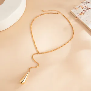 Vue détaillée d'un élégant collier en Y doré avec un pendentif goutte d'eau poli miroir