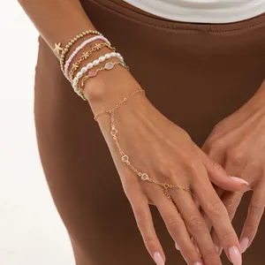 Vista detallada de pulseras de estrella de mar y perlas con cadena de mano de cristal.