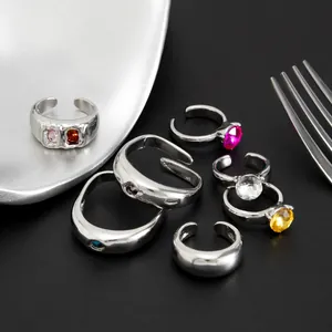 Detailopname van diverse zilveren open ringen met kleurrijke edelstenen.