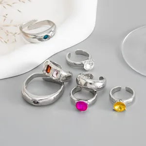 Detailweergave van zilveren open ringen met levendige kleurrijke strass-stenen