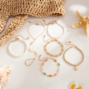 Variedad de pulseras doradas de temática marina con perlas, cristales y estrellas de mar.