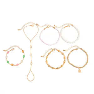 Vista detallada del conjunto de seis pulseras doradas con motivos de estrellas y perlas