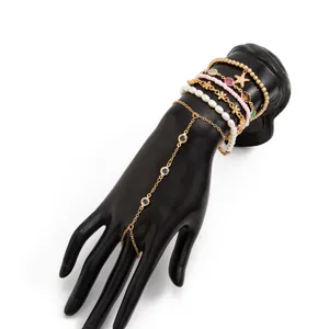 Detalle de cadena de mano de estrella de mar con cuentas coloridas en mano de maniquí negra.