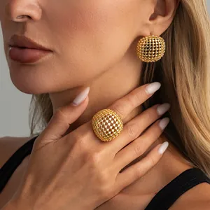Dettaglio di anello e orecchini retrò in maglia intrecciata dorata sulla modella