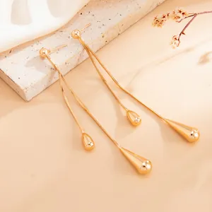 Detailansicht eleganter goldener Quastenohrringe mit glatten Wassertropfenanhängern
