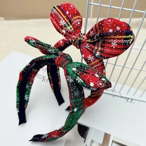 Festive Christmas bow headbands in red and green plaid fabric with white snowflake patterns
