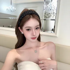 Serre-tête large noir élégant avec strass étoilés pour un look chic et volumineux.