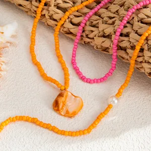 Close-up of colorful seed bead anklets with shell and pearl charms for beach vacation