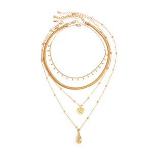 Vue détaillée d'un ensemble de colliers dorés multicouches avec pendentifs cœur et goutte.