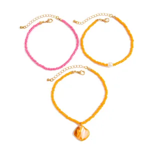 Close-up detail of colorful bohemian seed bead anklets with shell and pearl charms