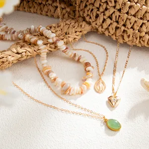Vue détaillée d'un collier en perles de coquillage et de pendentifs en forme de cœur dorés