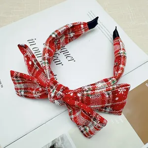 Festive red and white plaid Christmas bow headband featuring delicate snowflake patterns