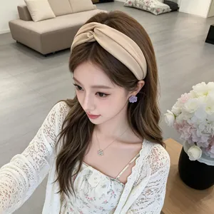 Beiger verknoteter Haarreif im koreanischen Stil, getragen von einem Modell in Innenräumen