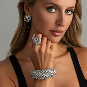 Primo piano di un bracciale rigido in rete metallica cava retrò sul polso di una modella
