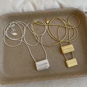 Vista detallada de elegantes collares de oro y plata con colgante de bolsa de metal tejido