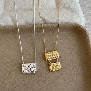 Detalle de collares con colgante de bolso tejido en elegantes acabados oro y plata