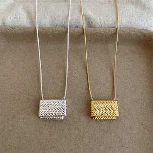 Primer plano detallado de collares de oro y plata con colgantes de metal trenzado