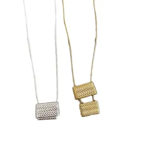 Elegantes collares con colgante de bolso tejido en oro y plata sobre fondo blanco