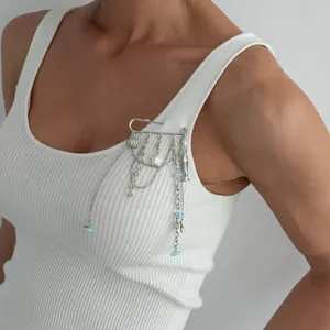 Détail d'une broche épingle à nourrice argentée avec breloques coquillage et étoile