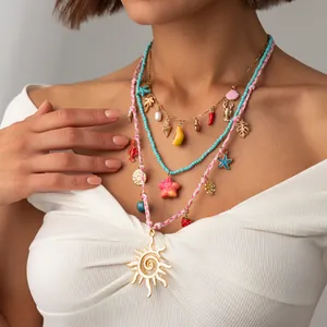 Vue détaillée de colliers bohèmes superposés avec pendentif soleil et étoile de mer