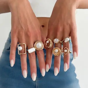 Detailansicht eines goldenen Vintage-Ring-Sets mit Barock- und Rundperlen an Händen