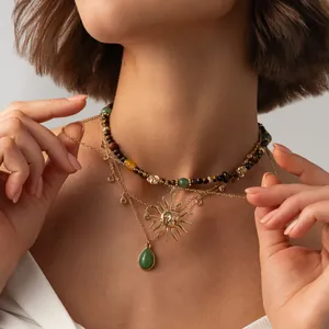 Gros plan d'un ensemble de colliers de style Maillard avec pendentif soleil doré