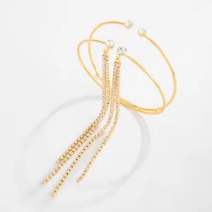 Dettaglio del bracciale da braccio a doppio strato dorato con nappe di strass