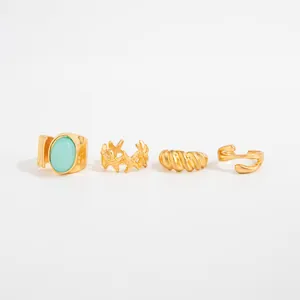 Vista detallada de cuatro anillos dorados para dedos con estrella de mar y turquesa.
