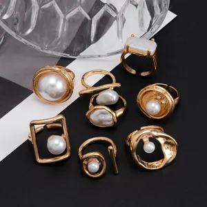 Makroaufnahme eines 8-teiligen goldenen Vintage-Ring-Sets mit Barock-Perlen.