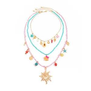 Vue détaillée d'un collier bohème coloré avec des breloques soleil, étoile de mer et mer.