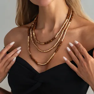 Close-up detail of a layered vintage metallic and wooden bead necklace worn by a model