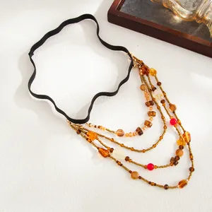 Close-up of Bohemian multi-layer beaded leg chain with amber and red accents