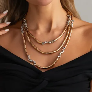 Close-up detail of three-layered metallic necklace featuring gold tubes and silver nugget beads